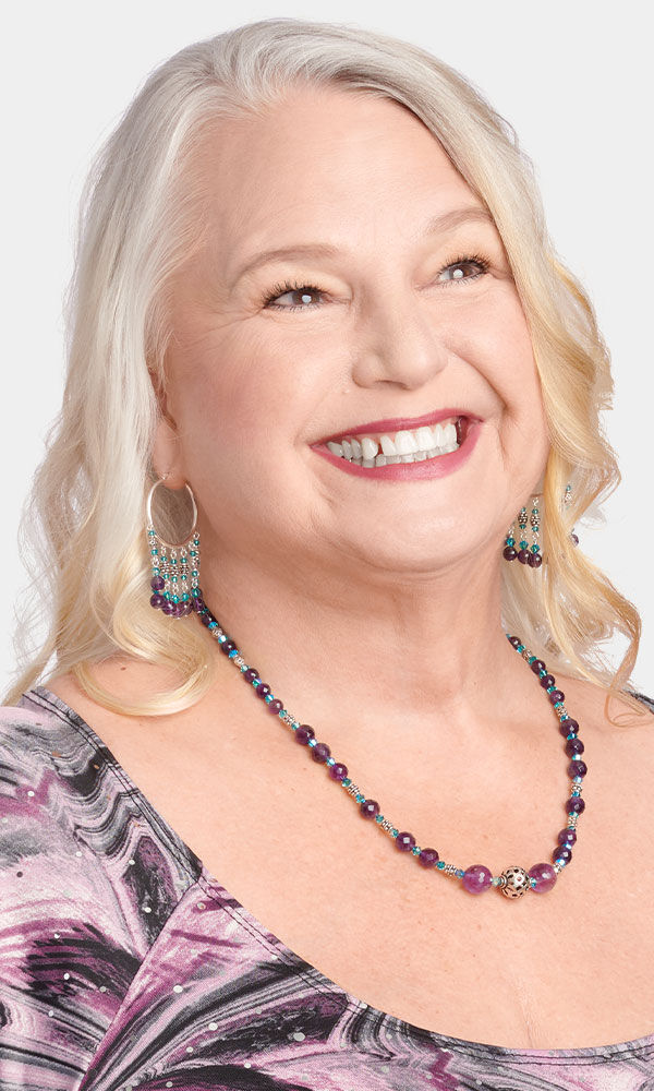 Model wearing an amethyst and metal bead necklace
